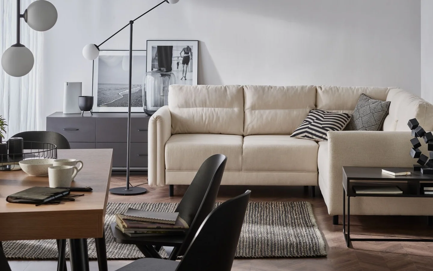 Sofa, dywan w salonie. Na pierwszym planie stół z krzesłami
